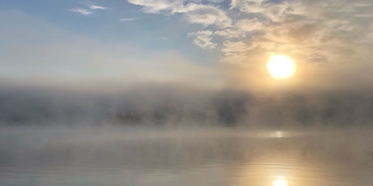 Sonne über einem See, mystischer Nebel breitet sich aus
